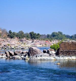 a river with some rocks and a castle in the background