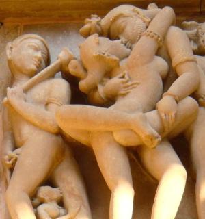 a statue of people on the side of a wall