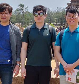 three young men standing in front of a temple
