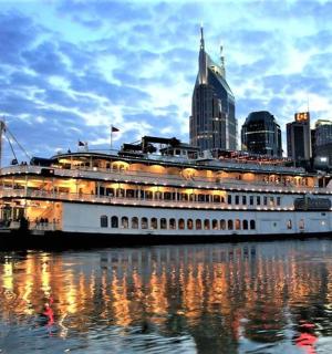 výletní loď na vodě s městem v pozadí