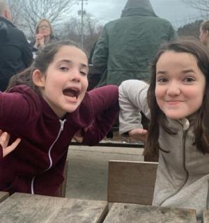 two young girls are posing for a picture at a table