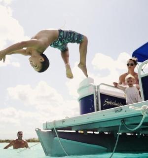ein Mann springt von einem Boot im Wasser