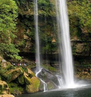 en gruppe mennesker står foran et vandfald
