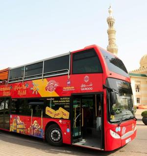 一辆红色双层巴士停在一栋建筑物前