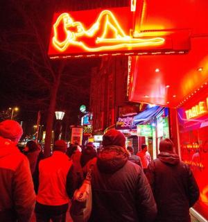 a crowd of people walking down a street at night