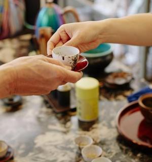 一个人拿着杯子放在桌子上