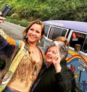 two women are taking a picture of a van