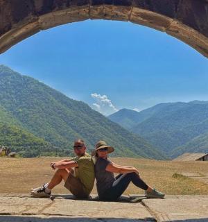 a man and a woman sitting under an archway