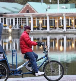 a man riding a bike with a cart on it