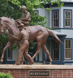 socha muže jedoucího na koni před domem