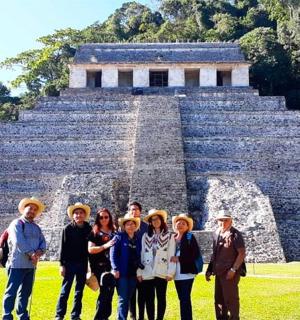 skupina lidí stojící před pyramidou