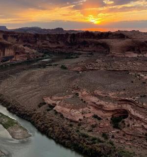 an aerial view of a river in a canyon at sunset