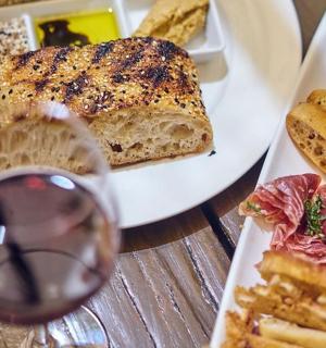 stůl se dvěma talíři jídla a sklenkou vína