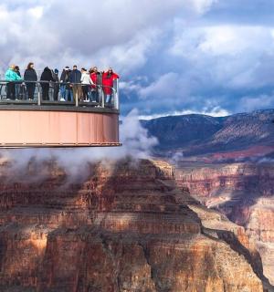 a group of people on a viewing platform at the grand canyon