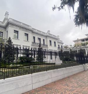 a large white building with a fence in front of it
