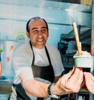 muž v kuchyni dává člověku kus jídla