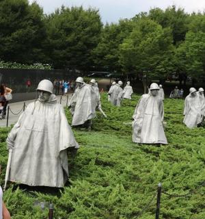 a woman standing in front of a group of people dressed in white