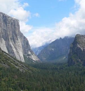 a view of a valley with mountains and trees