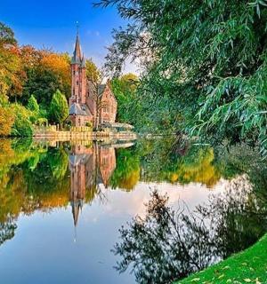 树木环绕的湖面上倒映着教堂