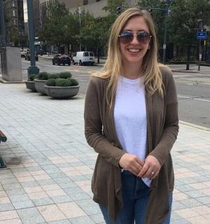 一位女士站在人行道旁的长椅上