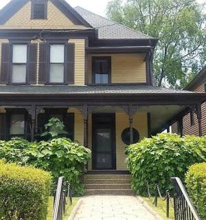 a yellow house with a staircase leading to the front door