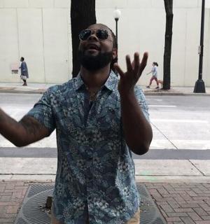 a man standing on a street with his hands up
