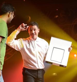 two men standing on a stage holding a box