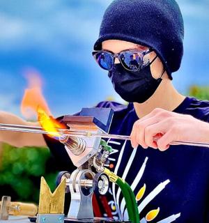 一名戴着面具的男子手持一根带火的棍子