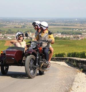 skupina lidí jedoucích na motorce s postranním vozíkem