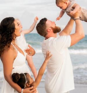 rodina si hraje na pláži s dítětem