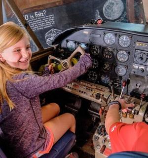 dvě děti sedící v kokpitu letadla