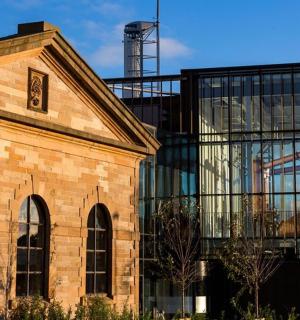 一栋建筑的窗户上倒映着一辆公共汽车