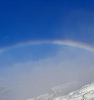 duha na obloze nad zasněženou horou