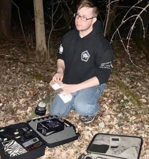 a man sitting on the ground next to a suitcase