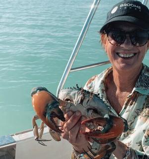 一名女子在船上抱着一只大龙虾