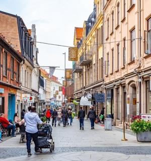 eine Gruppe von Menschen, die eine Straße mit Gebäuden entlanggehen