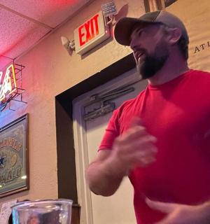 a man in a red shirt standing in a restaurant