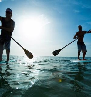 two men are standing on surfboards in the water