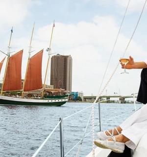 muž sedící na přídi plachetnice