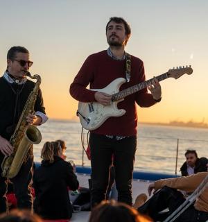 a group of men playing music on the beach
