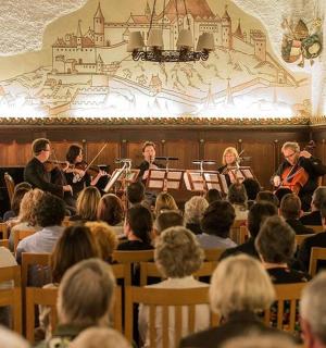 група људи који седе у соби уз музику