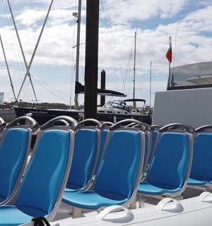 a row of blue chairs sitting on a boat