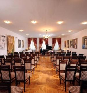 一间摆着几排椅子和一架钢琴的大房间