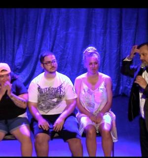 skupina lidí sedících na lavičce na pódiu