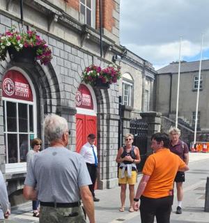 skupina lidí stojících před budovou