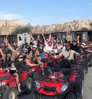 一群人坐在四轮车上,双手高举