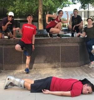 muž ležící na zemi před skupinou lidí