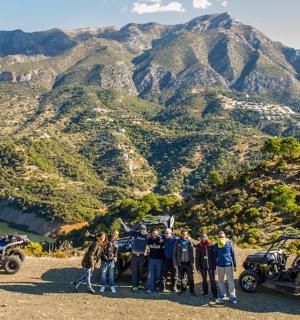 a group of people standing in front of a mountain