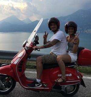 一名男子和一名儿童坐在一辆红色摩托车上