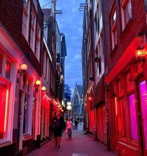 a group of people walking down a street with red lights